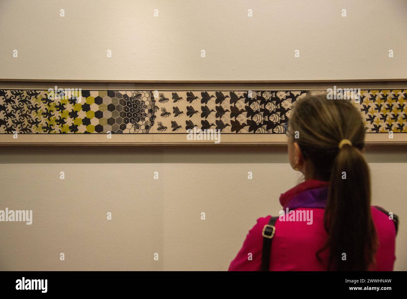 Besucher mit Blick auf „Metamorphose II“ des niederländischen Künstlers Escher in der Ausstellung Stockfoto