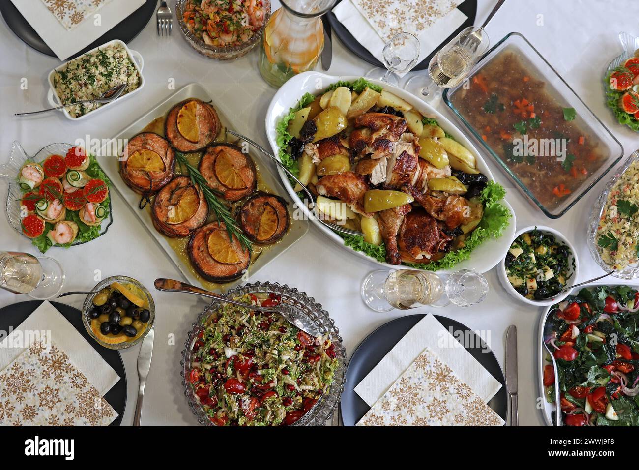 Tisch voll mit leckerem Essen auf Tellern, Blick von oben. Herzhaftes hausgemachtes Essen wunderschön präsentiert. Stockfoto