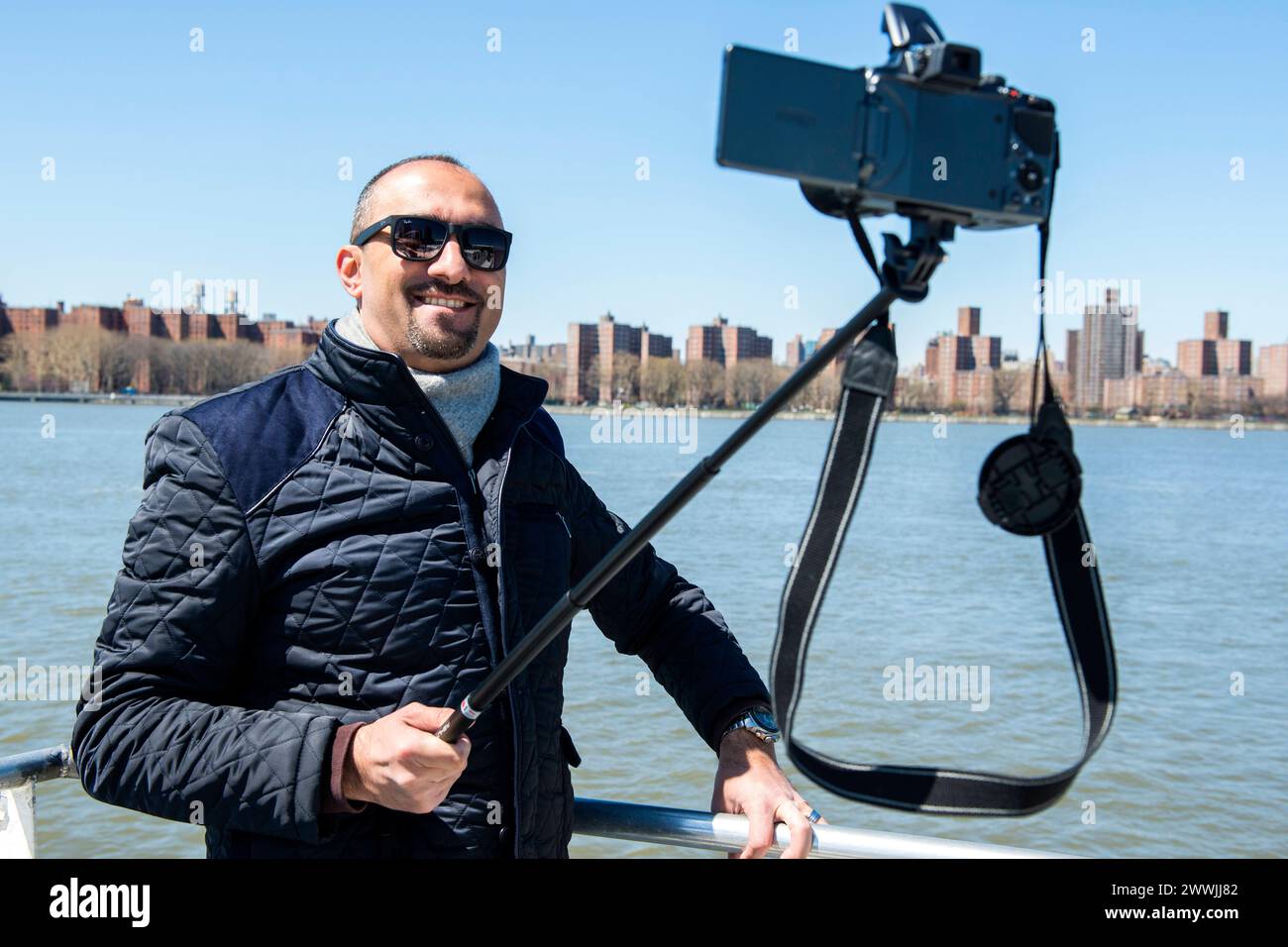 Glücklicher Mann, der Selfie in New York City, USA, macht. Mann, der Sonnenbrillen schwebt, macht ein Selfie, benutzt einen Selfie-Stock, während er eine Tour mit der East River Ferry macht. New York City East River Ferry New York Vereinigte Staaten von Amerika Copyright: XGuidoxKoppesx Stockfoto