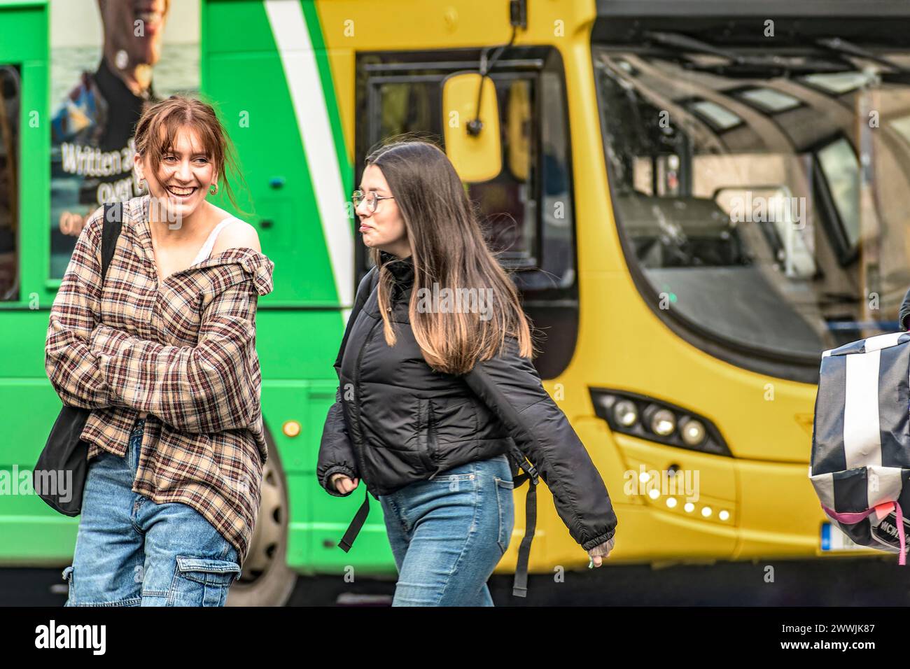 Straßenporträt einer glücklichen, stilvollen Frau mit ihrem Freund gegen den Dublin Bus, der Freude in der lebhaften Straße von Irlands Hauptstadt ausstrahlt. Dublin. Irland Stockfoto