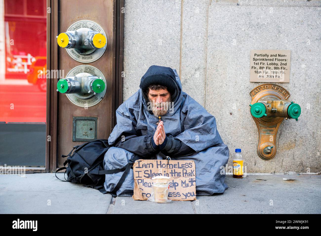 Obdachloser betet für einen Dollar New York City, USA. Obdachloser sitzt auf den Straßen von Manhttan und betet für einen Dollar. New York City Downtown, Manhattan New York Vereinigte Staaten von Amerika Copyright: XGuidoxKoppesx Stockfoto