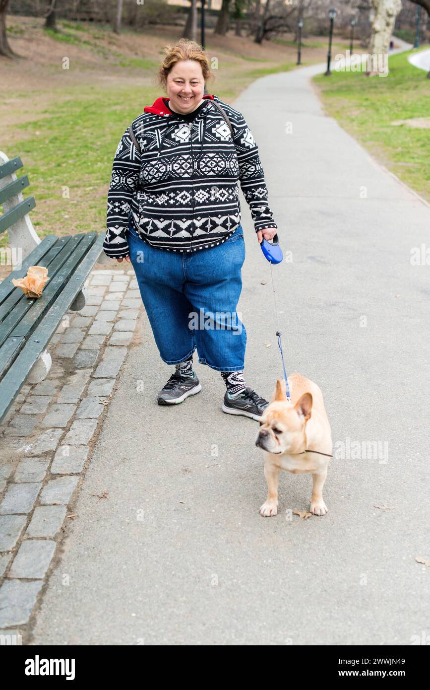 Dogwalker New York City, USA. Weibliche, kaukasische dogwalkerin, die den Hund eines ihrer Kunden durch Central Park, Manhattan, führt. MRYES New York City Central Park, Manhattan New York Vereinigte Staaten von Amerika Copyright: XGuidoxKoppesx Stockfoto
