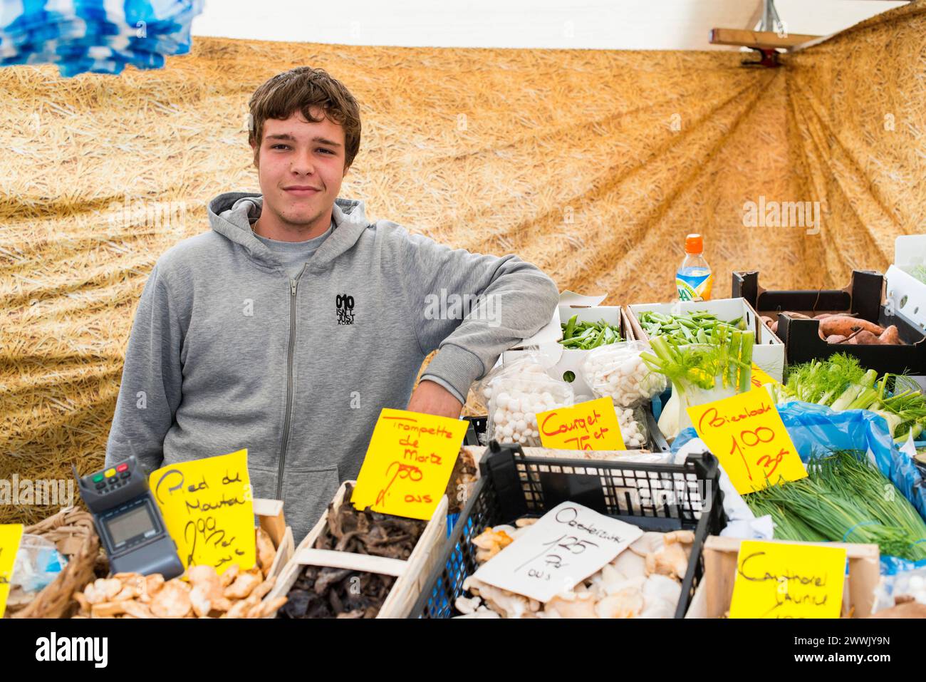 Der Kerl, der Lebensmittel verkauft Rotterdam, Niederlande. Junger Teenager, der Lebensmittel vom Marktstand seines Vaters verkauft. MRYES Rotterdam Blaak, dinsdagmarkt Zuid-Holland Nederland Copyright: XGuidoxKoppesx Stockfoto