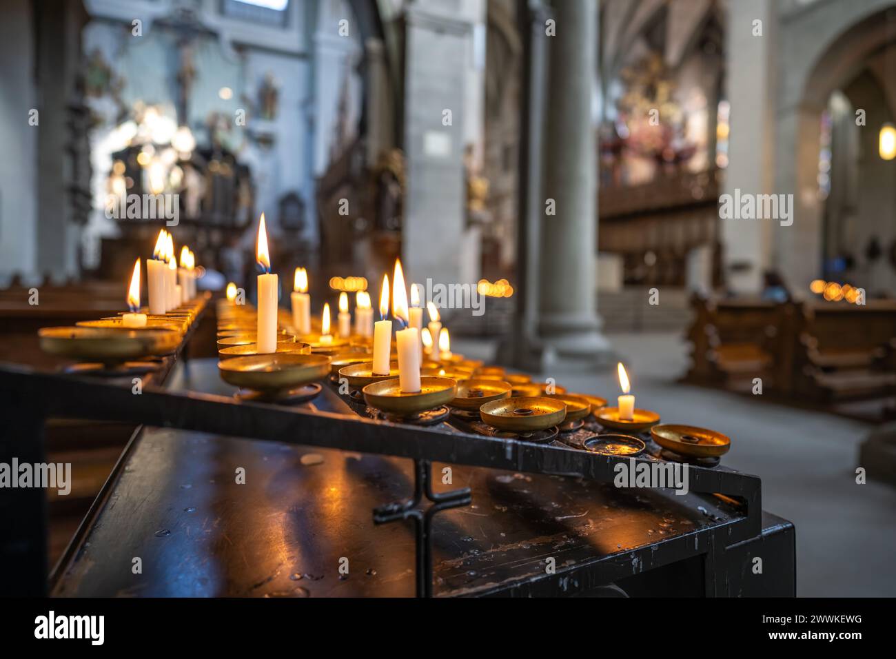 Beschreibung: Teelichter brennen im linken Seitengang einer hellen romanischen dreischiffigen Säulen-Basilika. Münster Unter Lieben Frau Konstanz, La Stockfoto