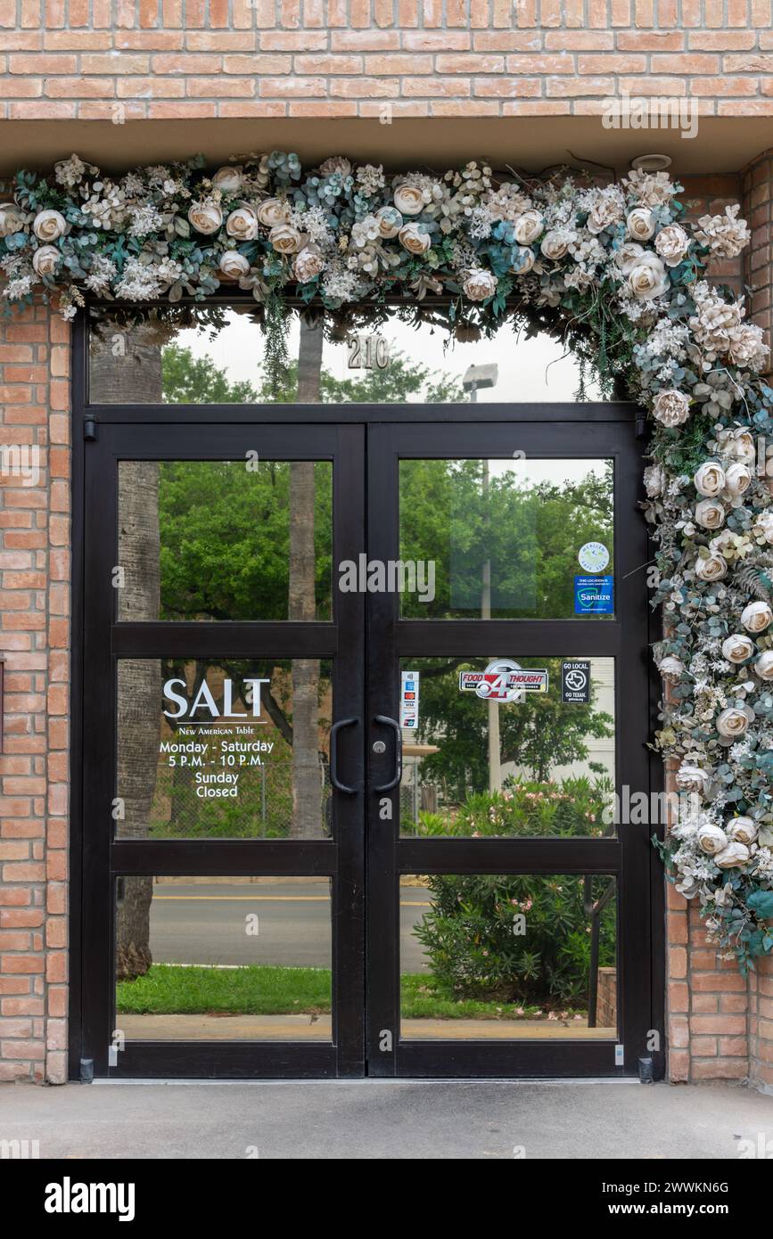 Doppeltür mit künstlichen Rosen im Salt New American Table Restaurant, Teil der Delgado Group, McAllen, Hidalgo County, Texas, USA. Stockfoto