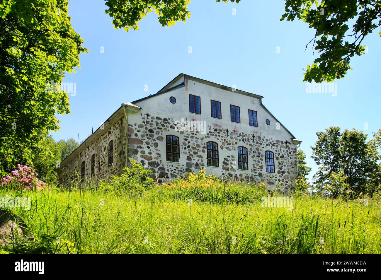 Sjundby Manor, eine mittelalterliche Steinburg aus den 1560er Jahren, und Garten in Siuntio, Finnland, am sonnigen Mittsommerabend 2022. Blick von der Karskogintie Road. Stockfoto