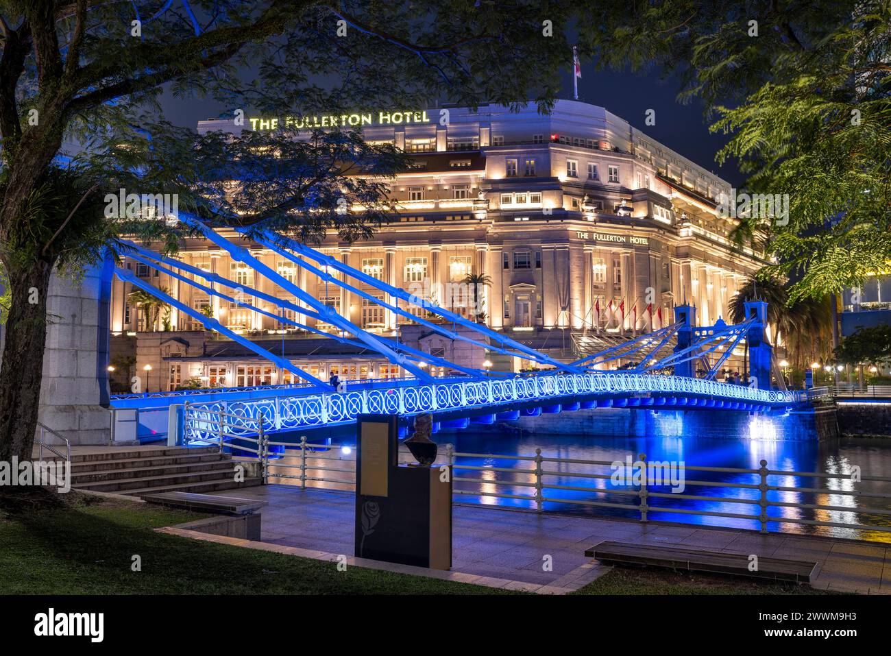Singapore River mit der Cavenagh Bridge und dem Fullerton Hotel in Singapur, während der abendlichen Atmosphäre Stockfoto
