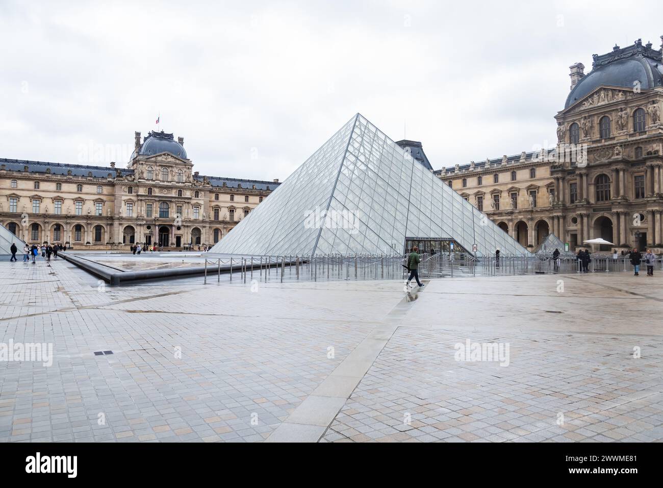 5. Dezember 2023 - Touristen vor der Glaspyamid am Eingang des Louvre-Museums in Paris, Frankreich Stockfoto