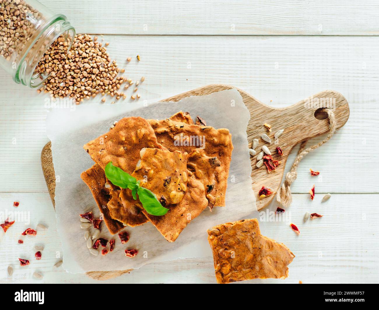 Glutenfreie Knäckebrot aus Buskweizenmehl. Grünes Buchweizenmehl geräuchertes Paprika Sonnenblumenkerne Zutaten hausgemachtes, gebackenes Knäckebrot. Idee Rezept Snacks glutenfreies Konzept. Draufsicht flach liegend Stockfoto