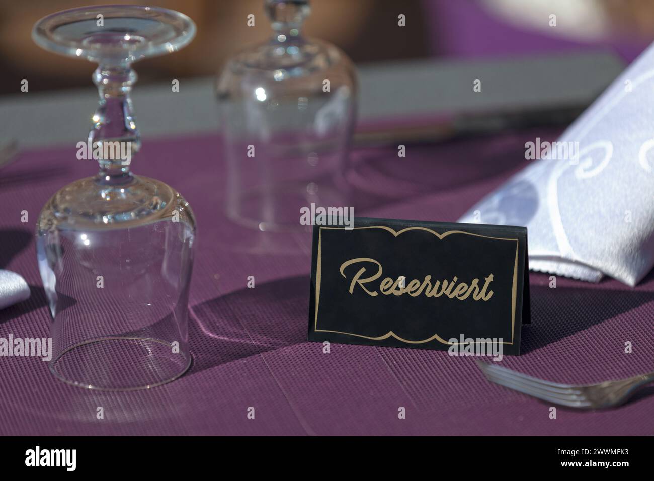 Tisch auf der Terrasse eines Restaurants mit einem Schild mit der Aufschrift „reserviert“, was auf englisch „reserviert“ bedeutet. Stockfoto