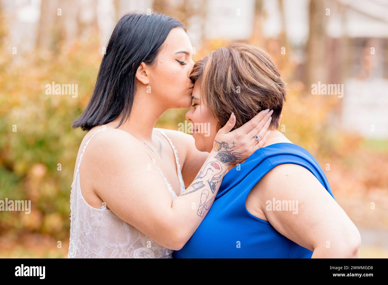 Tochter küsst ihre Mutter auf die Stirn Stockfoto
