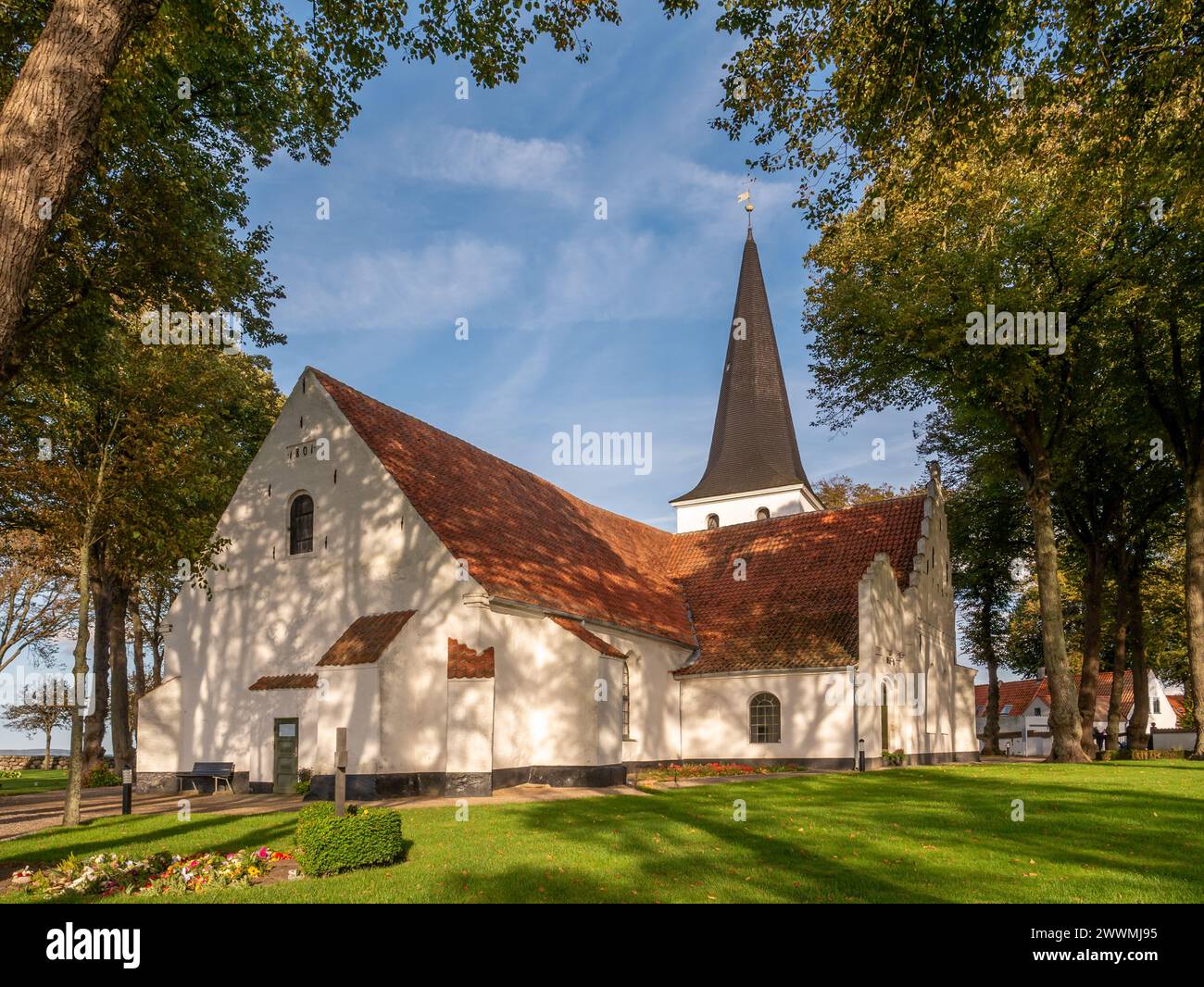 Die Nikolaikirche liegt im Herbst zwischen Bäumen in der Altstadt von Bogense, Fünen, Dänemark Stockfoto
