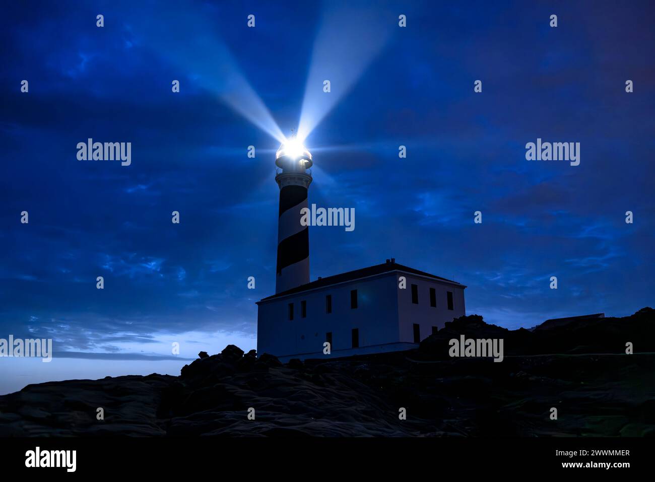 Favàritx Leuchtturm, bei Nacht, mit der Beleuchtung der Lichtstrahlen des Leuchtturms (Menorca, Balearen, Spanien) ESP: Faro de Favàritx Stockfoto