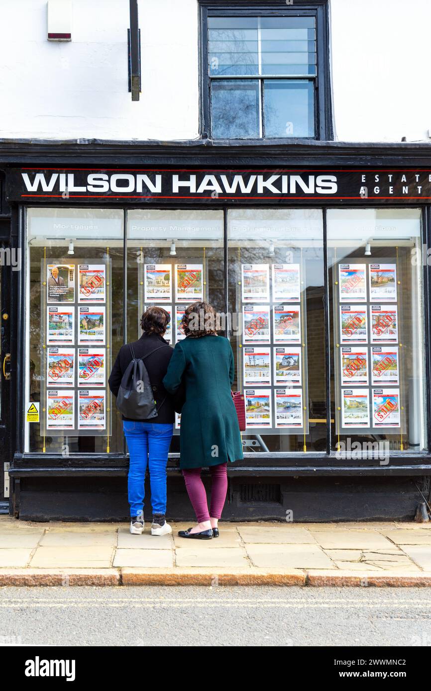 Frauen, die sich Immobilienplakate an einem Immobilienmakler ansehen, Harrow, London, England Stockfoto