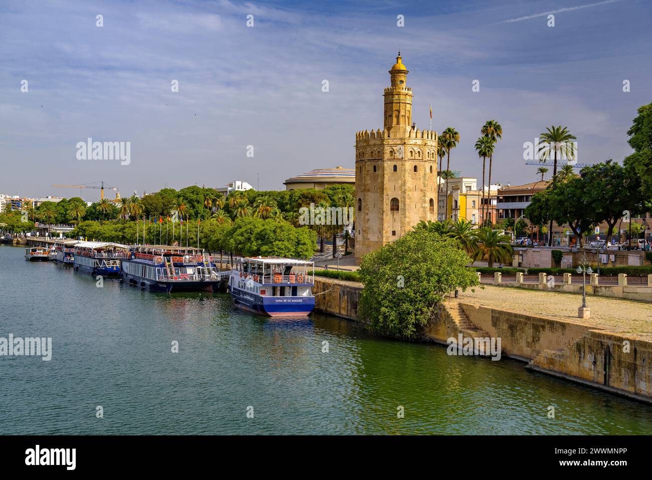 Traditioneller Blick auf Sevilla mit dem Torre del Oro und dem Fluss Guadalquivir mit einigen Booten (Sevilla, Andalusien, Spanien) Stockfoto