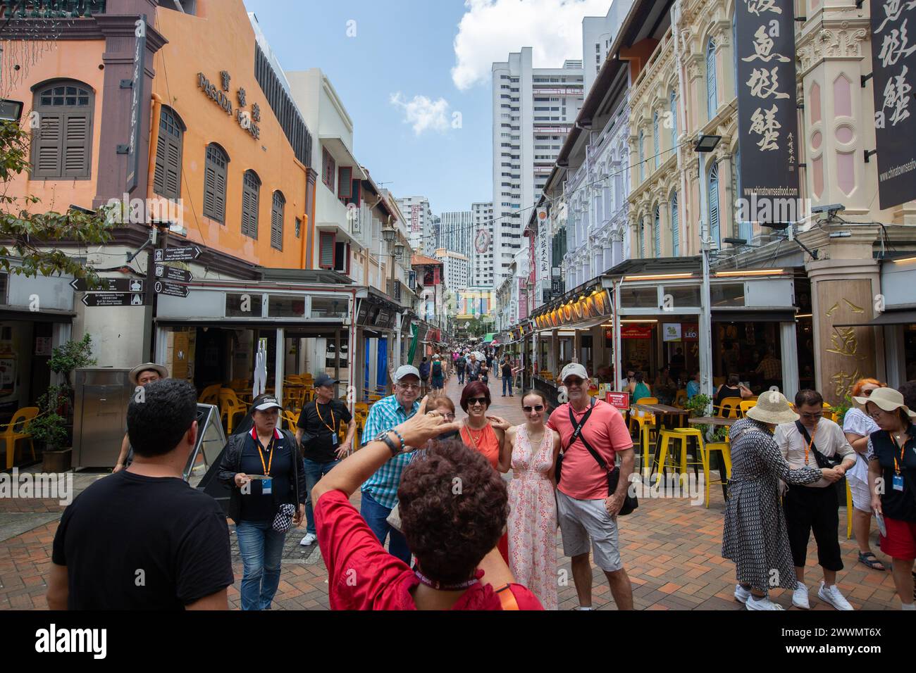 Glückliche Touristen aus Übersee posieren für ein Erinnerungsfoto in der Straße von Chinatown Wahrzeichen. Singapur. Stockfoto