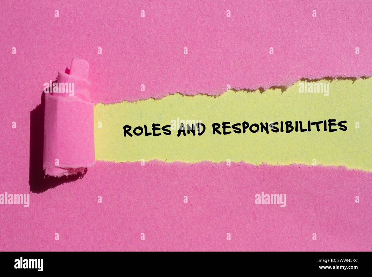 Rollen- und Verantwortungsworte auf rosafarbenem Papier mit gelbem Hintergrund. Konzeptsymbol. Kopierbereich. Stockfoto