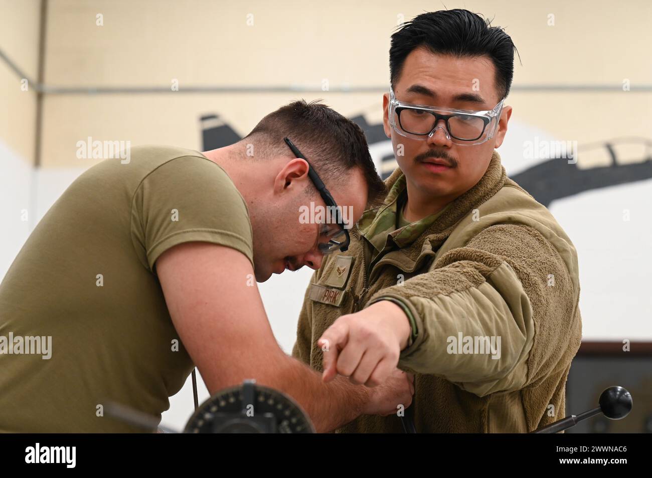 US Airmen 1st Class Luke Parkes and Rae Park, 509th Maintenance Group, Handwerker für die strukturelle Instandhaltung von Flugzeugen, fertigen und fertigen die Metallteile auf der Whiteman Air Force Base, Mo., 15. Februar 2024. Parken weist Parkes an, mehr Material durch die Maschine zu ziehen, um das Teil korrekt herzustellen. Luftwaffe Stockfoto