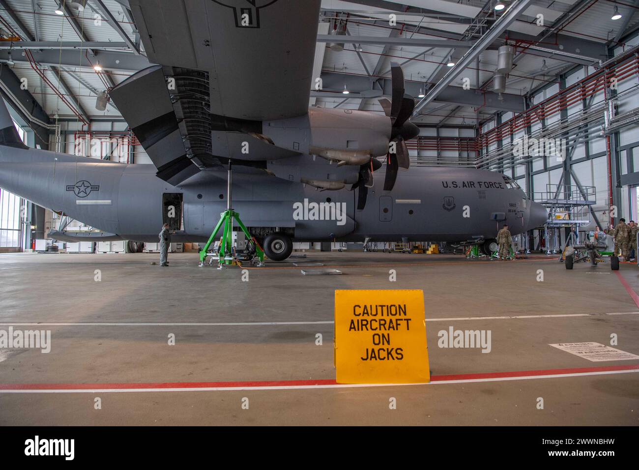 Mitglieder der 86th Maintenance Group heben einen C-130J Super Hercules mit einem elektronischen Heber- und Nivelliersystem auf der Ramstein Air Base, Deutschland, 22. Februar 2024. Die 86. MXG arbeitete mit mehreren Agenturen zusammen, um festzustellen, ob das EJALS mit C-130Js kompatibel ist. Luftwaffe Stockfoto