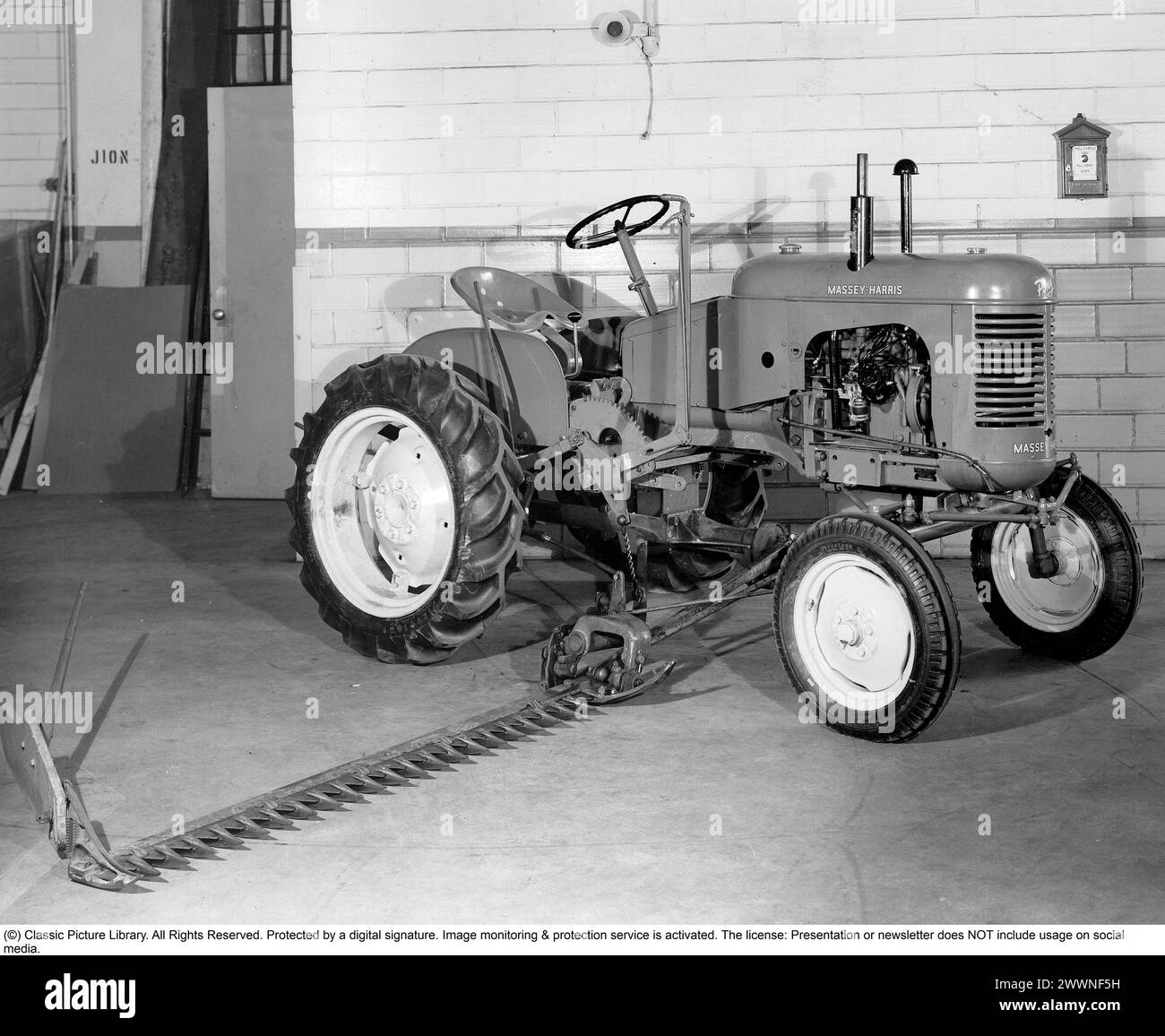 Massey Harris Traktor. Der Pony-Traktor Modell 11 wurde 1947 mit 28746 produzierten Traktoren eingeführt, bis die Produktion 1957 endete. Der kleinste Traktor der Massey Harris-Linie. Der Traktor ist mit einer angebrachten Schneideinheit ausgestattet, die zum Schneiden von Grasfeldern oder anderen Anbaukulturen verwendet wird. Stockfoto