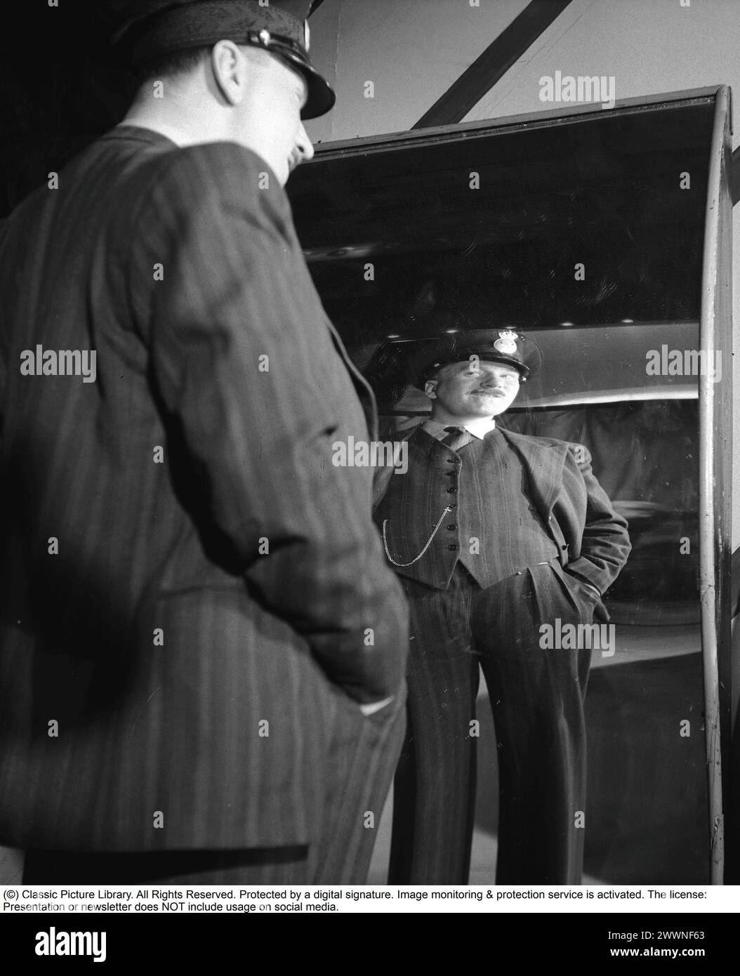 Lachende Spiegel 1947. Schauspieler Sigge Furst in der Spiegelattraktion Skrattkammaren im Vergnügungspark Gröna Lund, wo er sich in einem lachenden Spiegel sieht. Normale Spiegel haben eine flache Oberfläche, während die Spiegel in einem Vergnügungspark sowohl nach innen als auch nach außen gewölbt, konkav und konvex sein könnten. Ein Spiegel lässt einen hoch und dünn aussehen. Andere spiegeln kurz und dick. 1947. Kristoffersson Ref. AE45-11 Stockfoto