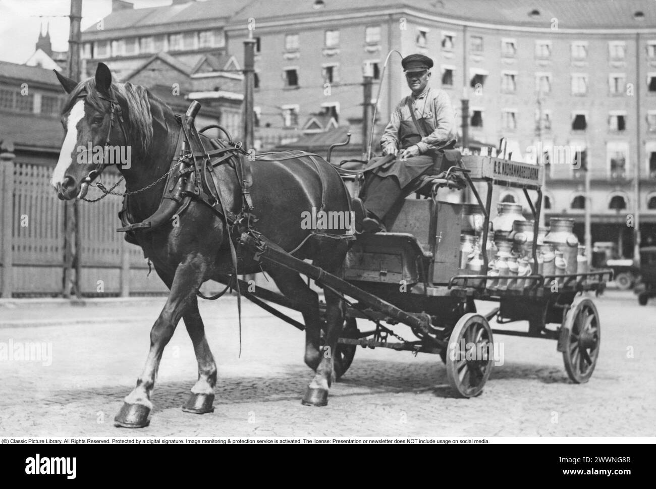 In den 1930er Jahren Ein Pferd und eine Kutsche Bilder in einer Stockholmer Straße 1936. Der Pferdewagen hat eine Ladung großer Milchflaschen. Stockfoto