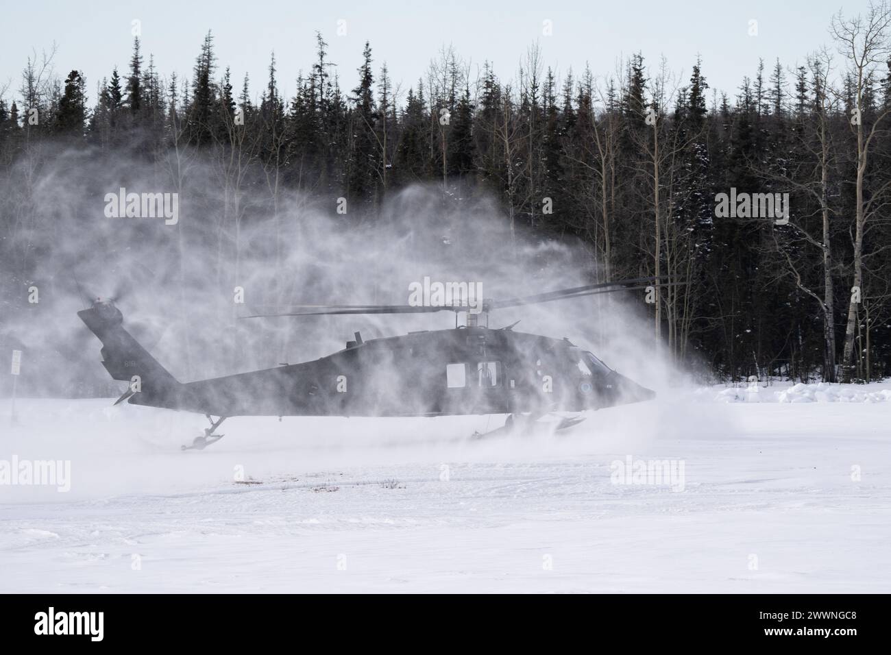 Snow beginnt, als ein Hubschrauber der Alaska Army National Guard UH-60L Black Hawk landet, während er am 28. Februar 2024 das Trainieren von Schleuderlasten auf der Joint Base Elmendorf-Richardson unterstützt. Soldaten der US-Armee des Alaska Army National Guard Aviation Battalion führten das mit Schleudern beladene Training durch, um ihre Einsatzfähigkeit in Alaskas rauer Umgebung zu verbessern. (Alaska Nationalgarde Stockfoto