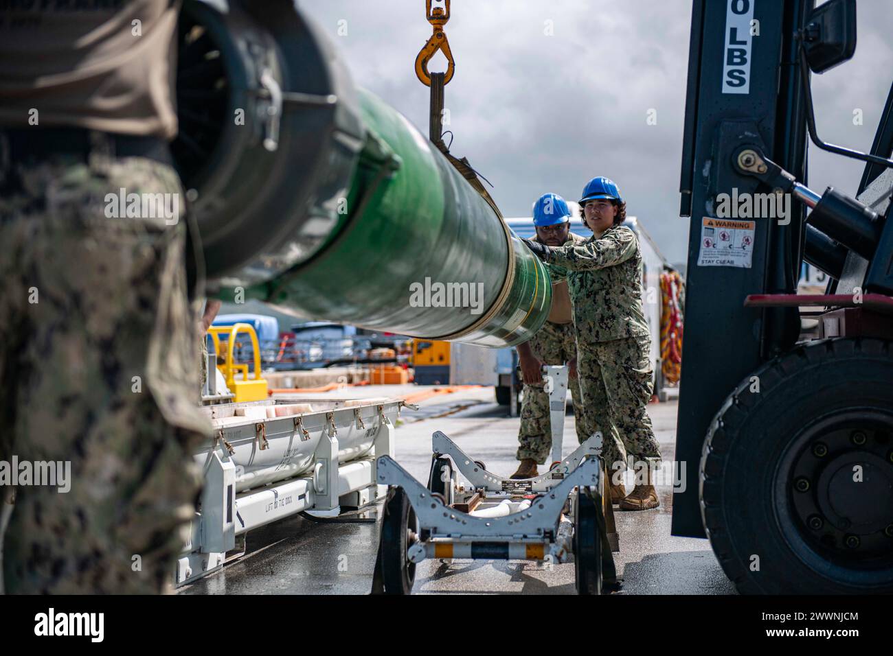 240215-N-VC599-1015 US-MARINEBASIS GUAM (15. Februar 2024) – Seeleute, die dem U-Boot-Tender der Emory S. Land-Klasse USS Frank Cable (AS 40) zugeordnet sind, führen einen Mark 48 Torpedo während einer Waffenladung des U-Boots der Los Angeles-Klasse USS Annapolis (SSN 760) auf der US-MARINEBASIS Guam am 15. Februar. Annapolis ist eines von mehreren U-Booten, die Commander, Submarine Squadron (CSS) 15 zugewiesen sind. CSS-15 befindet sich am Polaris Point, US-Marinestützpunkt Guam (NBG). Die NBG ist strategisch positioniert, um alle U-Boote zu unterstützen, die zur 7. US-Flotte eingesetzt werden, und beherbergt mehrere U-Boote der Los Angeles-Klasse. Na Stockfoto