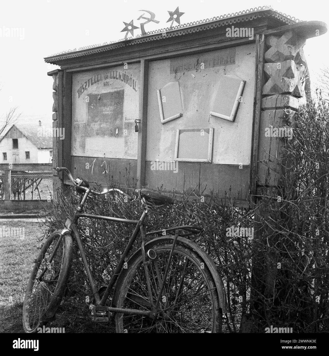 Harghita County, Sozialistische Republik Rumänien, ca. 1976. Eine zweisprachige Pinnwand (auf Ungarisch und Rumänisch) mit den kommunistischen Symbolen oben im Hof einer landwirtschaftlichen Staatsgenossenschaft (C.A.P.). Stockfoto