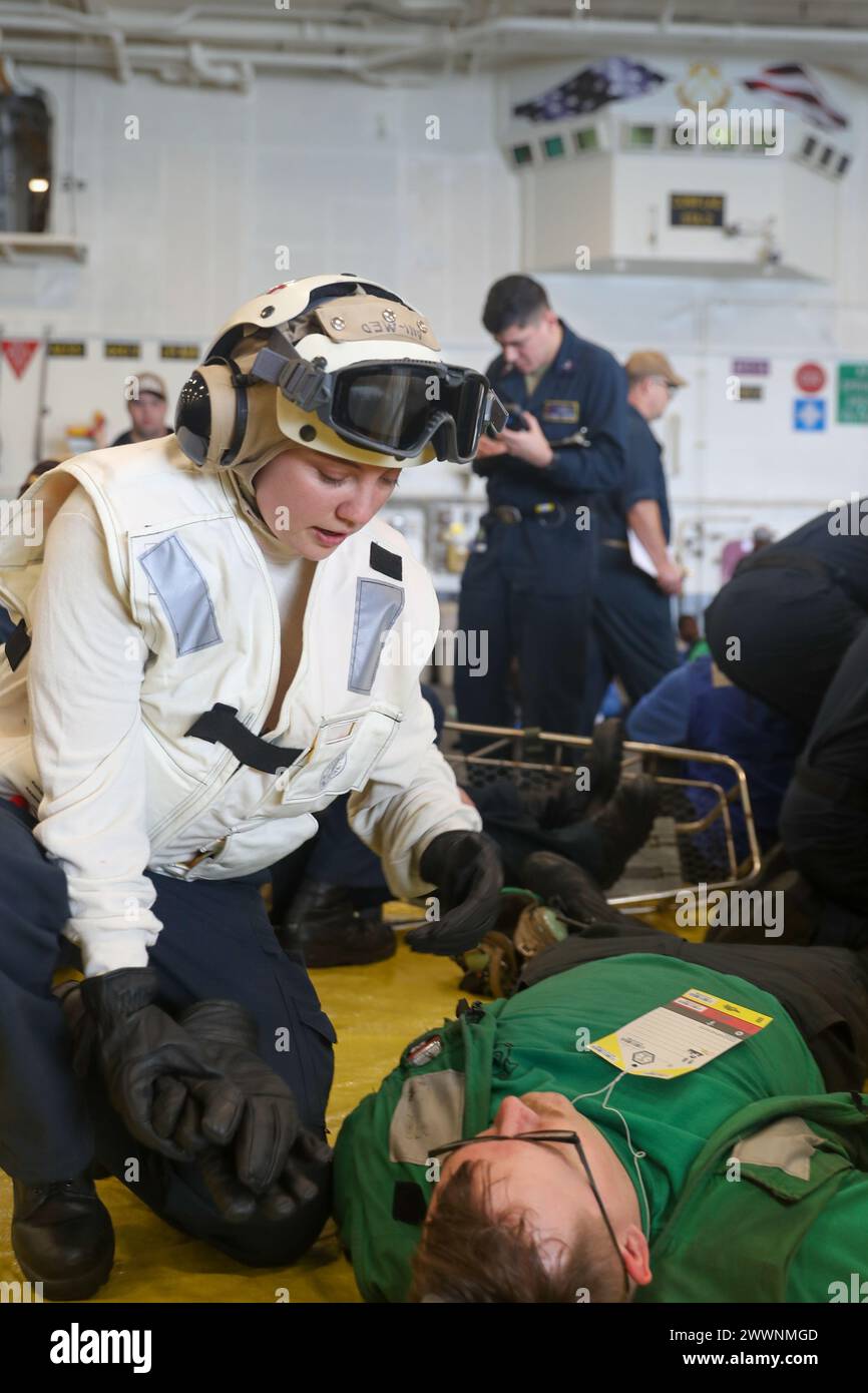 Krankenhaus Corpsman 3rd Class Kasey R. Reynolds aus Reno, Nevada, der Helicopter Sea Combat Squadron (HSC) 5 zugeteilt wurde, nimmt an einer Massenübung an Bord eines Flugzeugträgers der Nimitz-Klasse USS George Washington (CVN 73) im Atlantik Teil, 19. Februar 2024. George Washington führt TSTA/FEP (Tailored Ships Training Availability and Final Evaluation Problem) durch. TSTA/FEP bereitet das Schiff und die Besatzung auf die vollständige Integration in die Trägerstreikgruppe durch eine breite Palette von missionskritischen Operationen vor. Marineblau Stockfoto