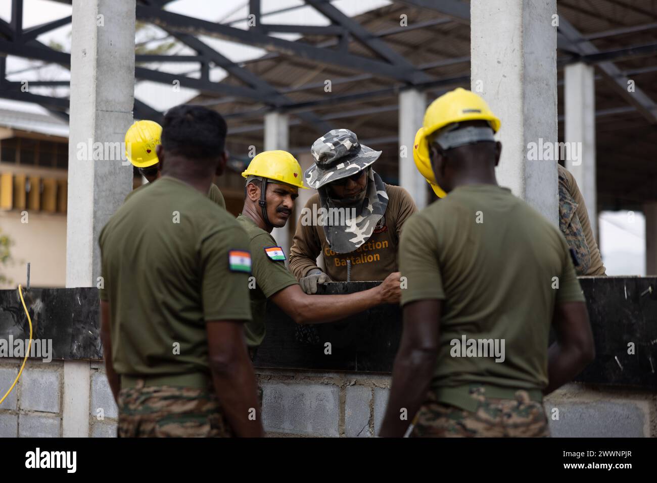 Indische Soldaten mit dem Ingenieur-Korps der Indischen Armee bereiten am 16. Februar 2024 eine Betonschicht in der Bankhaocha-Angkromklong-Schule in Rayong, Thailand vor. Die Marines der MWSS-174 haben ihr technisches Fachwissen für multilaterale humanitäre Bemühungen während der Cobra Gold 24 bereitgestellt. Cobra Gold ist die größte gemeinsame Übung auf dem asiatischen Festland und ein konkretes Beispiel für die starke Allianz und strategische Beziehung zwischen Thailand und den Vereinigten Staaten. In diesem Jahr findet die 43. Wiederholung der multilateralen Übung vom 27. Februar bis 8. März 2024 statt. Marine Corps Stockfoto