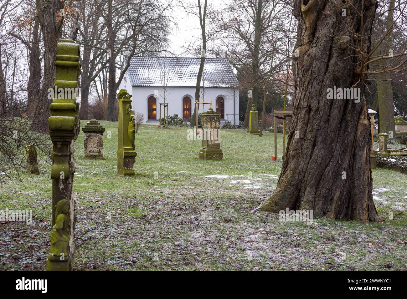 Licht in der Kapelle auf dem Friedhof, alte Grabsteine und etwas Schnee an einem grauen Tag, Riesa, Sachsen, Deutschland *** Licht in der Kapelle am Th Stockfoto