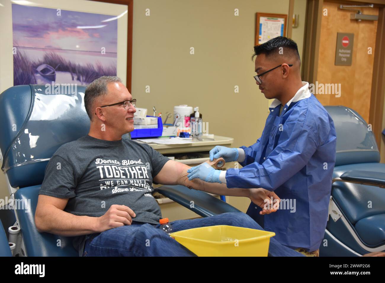 Scheidender Stabschef des US Army Surgeon General, U.S. Army Medical Command, und der stellvertretende Kommandant General (Support), US Army Medical Command, Generalmajor Michael Place wird unterstützt von SPC. Enrique Urquico, Phlebotomist Fort Liberty Blood Spender Center, während er seine letzte Blutspende als aktives Dienstmitglied am 16. Februar vollendet. (DHA Stockfoto