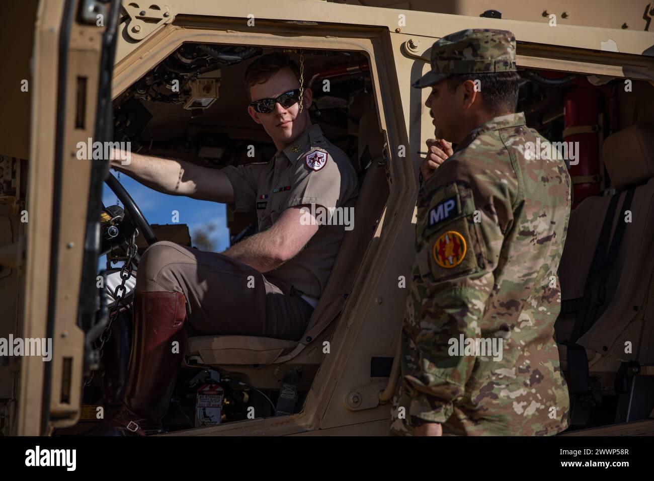 1. Lieutenant Michael Patrino, rechts, ein Zugführer der 410. Militärpolizeikompanie, 720. Militärpolizeibataillon, 89. Militärpolizeibrigade, zeigt während des Texas A&M Meet Your Army Day Events 7. Februar 2024 einen ROTC-Kadett im Inneren eines minenresistenten, überfallsicheren Geländefahrzeugs. in College Station, Texas. Während des „Meet Your Army Day“ können sich ROTC Cadets, JROTC Cadets sowie Texas A&M Studenten mit Soldaten treffen und mehr über die Jobs und Möglichkeiten erfahren, die den Armeeoffizieren angeboten werden, sobald sie in dienst gestellt haben. Armee Stockfoto