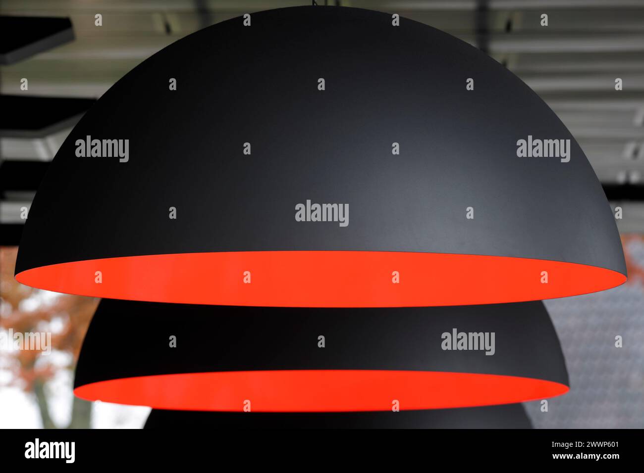 Deckenlampen mit Halbkugel und orangefarbener Inneneinrichtung im Restaurant. Dutch Institute For Sound & Vision, Hilversum, Niederlande. Architekt: Neutelings Riedijk Stockfoto