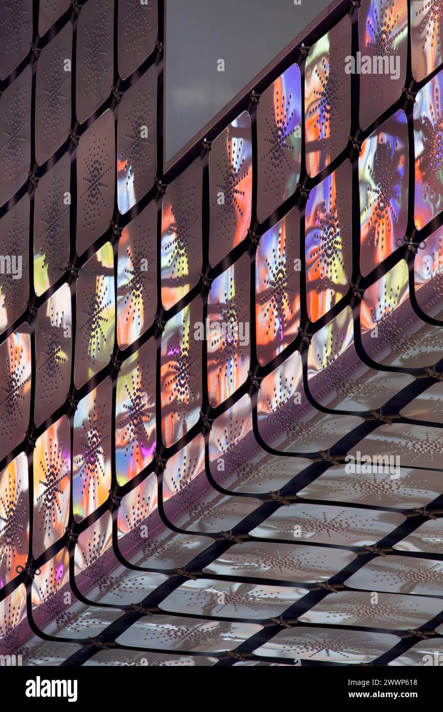 Reflexionen von mehrfarbiger Glasfassade auf Aluminiumplatten auf Ziggurat im Atrium. Dutch Institute For Sound & Vision, Hilversum, Niederlande. Bogen Stockfoto