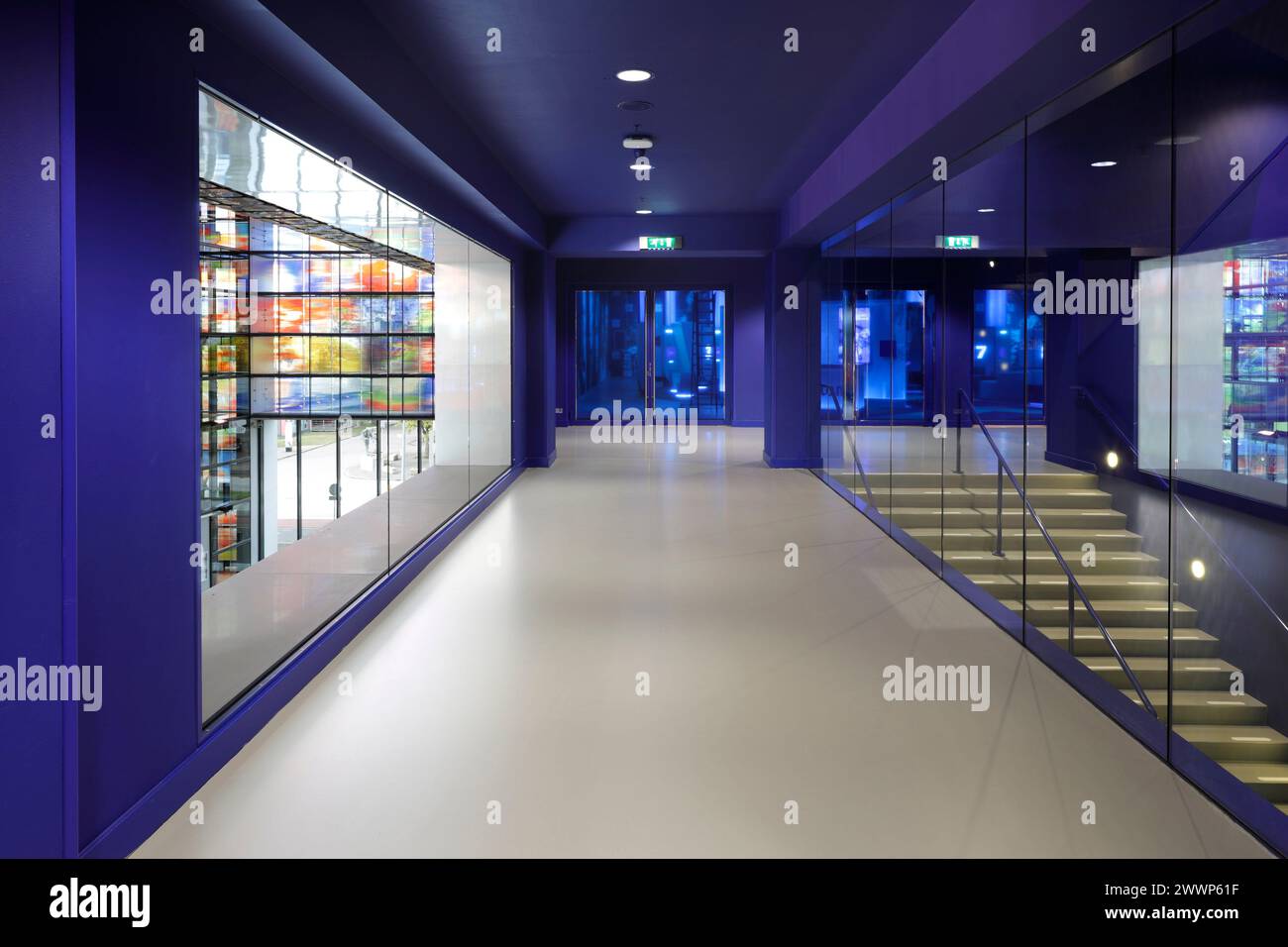 Blau bemalter Flur mit Blick auf das Atrium, mit Treppe, die zum Museum führt. Dutch Institute For Sound & Vision, Hilversum, Niederlande. Architekt: Ne Stockfoto