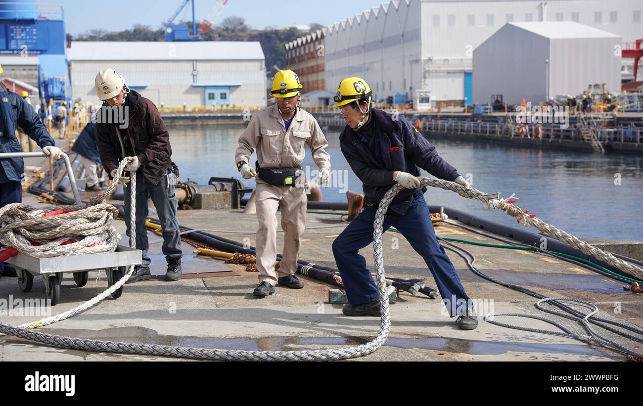 YOKOSUKA, Japan (18. Februar 2024) – Mitarbeiter der U.S. Naval Ship Repair Facility und des Japan Regional Maintenance Center (SRF-JRMC) führen das Abdocken des Zerstörers der Arleigh Burke-Klasse USS Benfold (DDG-65) vom Dry Dock 4 an Bord des Commander Fleet Activities Yokosuka (CFAY) aus, 18. Februar 2024. Jedes Abdocken ist eine komplexe Entwicklung, die Teamarbeit über die gesamte Uferpromenade hinweg erfordert, um ein sicheres und pünktliches Ereignis zu gewährleisten. Seit mehr als 75 Jahren sind die U.S. Naval Ship Repair Facility und das Japan Regional Maintenance Center (SRF-JRMC) das Dreh- und Angelpunkt der US-Marineoperationen in der Region Indo-Asien-Pazifik von pro Stockfoto