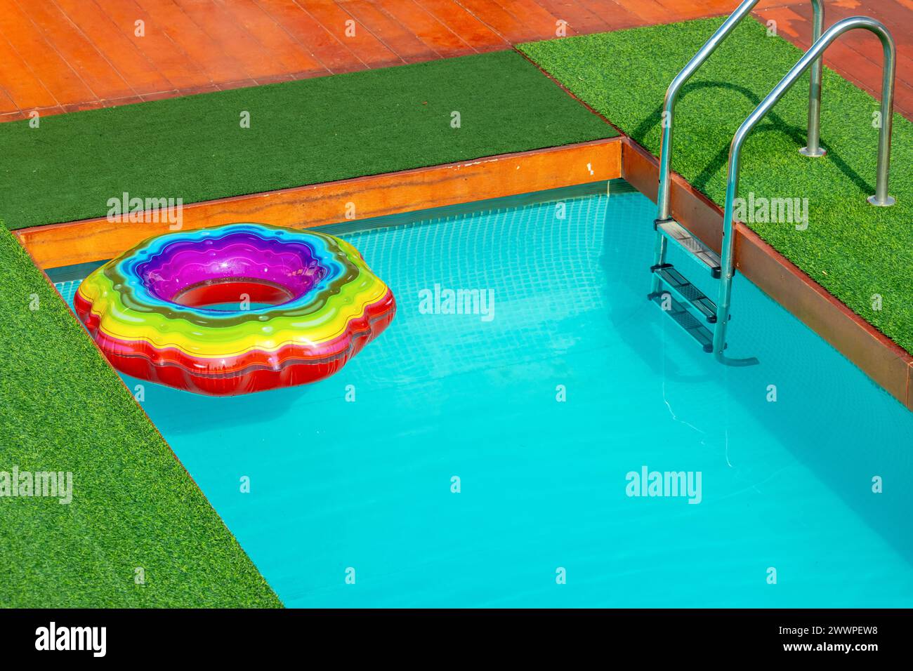 Farbenfroher aufblasbarer Ring auf der Oberfläche des Schwimmbades Stockfoto