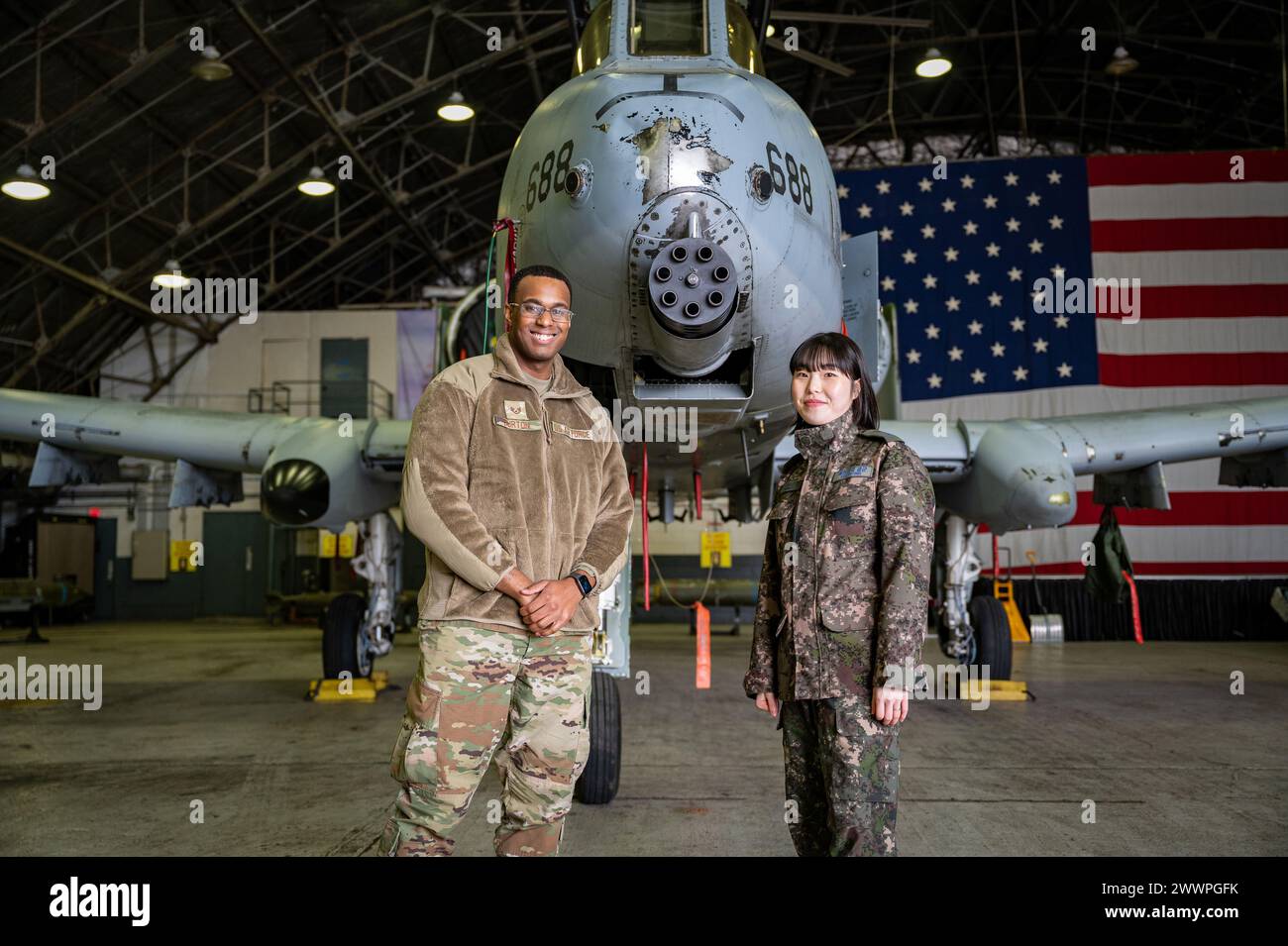 Darius Burton, Stabsleiter der US Air Force, links, 51st Communications Squadron Client Systems Technician und Republic of Korea Air Force Tech. Sgt. Lee, Gyu bin, ROKAF-Kommunikationsspezialist, posiert für ein Foto vor einem A-10C Thunderbolt II während eines Unteroffiziergipfels auf der Osan Air Base, Republik Korea, 22. Februar 2024. Auf dem Gipfel wurden 51st Fighter Wing Airmen mit ihren ROKAF-Kollegen in ähnlichen Karrierefeldern zusammengeführt, um das gegenseitige Verständnis der operativen Taktiken des jeweils anderen zu fördern und die Bereitschaft für Friedenszeiten und Eventualszenarien zu verbessern. Luft Für Stockfoto