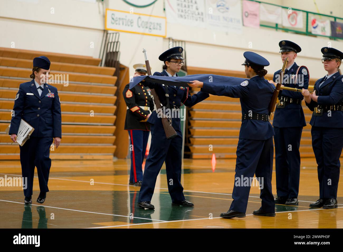 GEMEINSAME BASIS ELMENDORF-RICHARDSON, Alaska - Alaska Air National Guard Tech. Sgt. Cynthia Campbell (links), 176th Medical Group Clinical Services, beurteilt die Leistung von Junior ROTC-Kadetten während des landesweiten JROTC-Bohrwettbewerbs am 17. Februar 2024 in Alaska an der Service High School von Anchorage. Campbell war ein JROTC-Kadett in der High School und schreibt ihren Dienst dem Programm zu. (Alaska Air National Guard Stockfoto