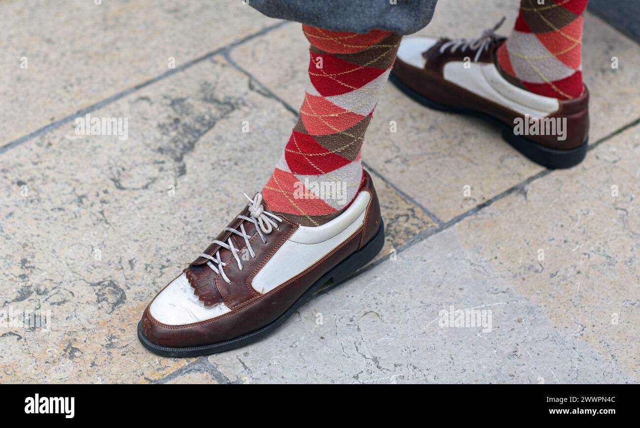 Nahaufnahme von zweifarbigen Lederschuhen und burlington-Socken Stockfoto