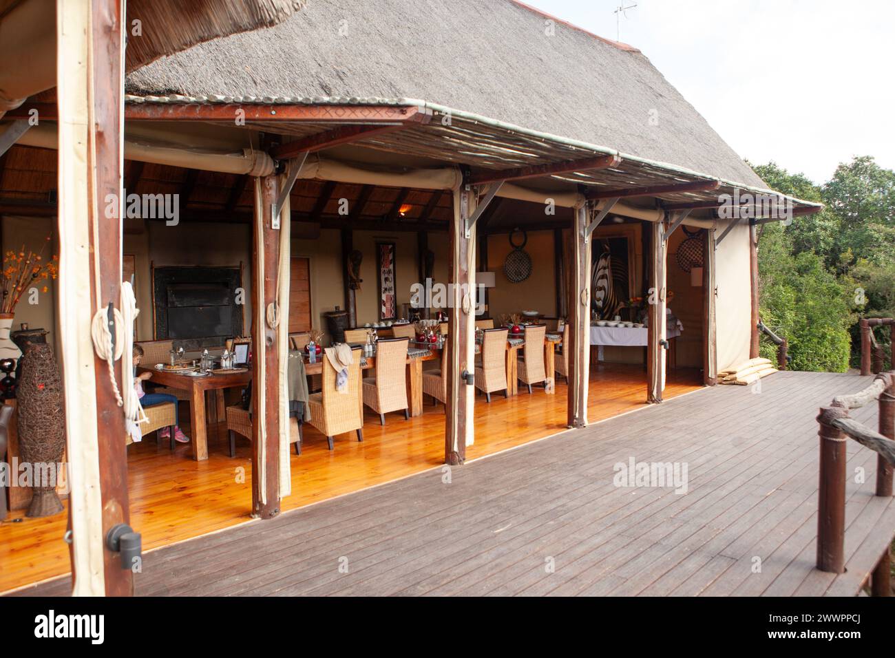 Das Innere der Haupthütte mit dekorativen afrikanischen Gegenständen im Amakhala Game Reserve, Südafrika, wo die Gäste sich vor der Fahrt treffen und essen. Stockfoto