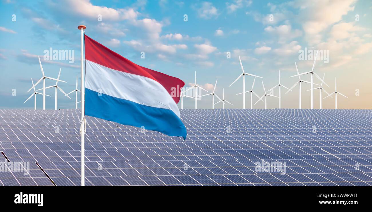 Offizielle Flagge der Niederlande vor einer großen Anzahl von Solarpaneelen und Windturbinen Stockfoto
