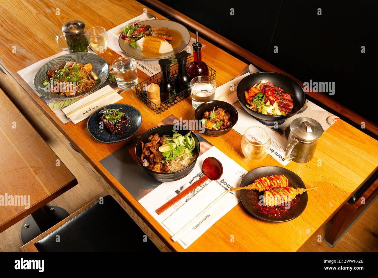 Verschiedene Gerichte auf dem Tisch im Wagamama Restaurant in Goodramgate in York, North Yorkshire. Stockfoto