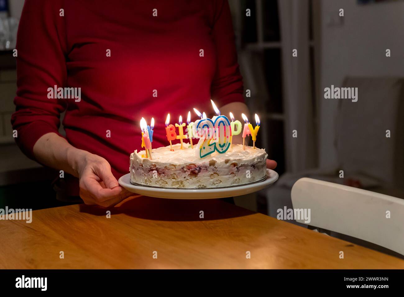 Hände mit Streichhölzern zünden vax Kerzen auf Geburtstagskuchen an Stockfoto