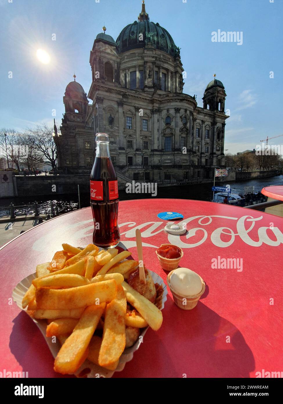 Eine Coca Cola und deutsche Pommes frites mit Blick auf den berühmten Berliner Dom in Berlin Stockfoto