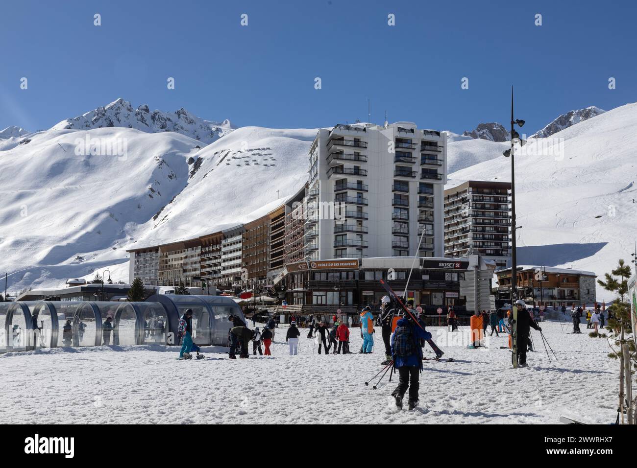 Der Hauptplatz im Skigebiet Tignes in Frankreich, dominiert von der mehrstöckigen „Unité touristique“ aus der Zeit der 1960er Jahre und dem Gipfel der Pointe du Chardonnet. Stockfoto