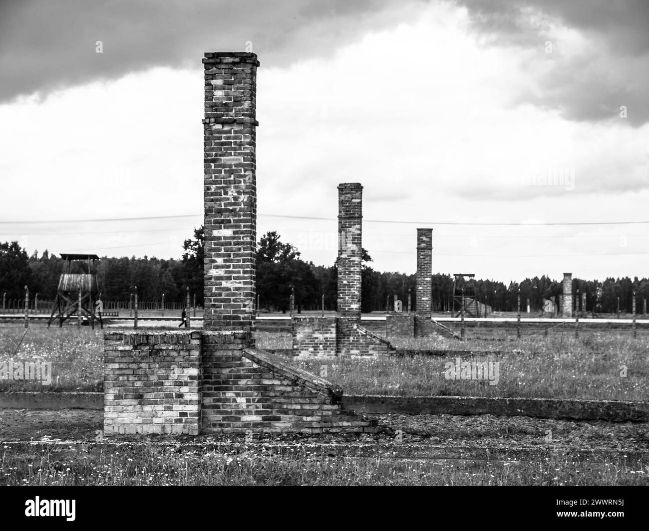 Gemauerte Schornsteine in Ruinen von Unterkunftsgebäuden im Konzentrationslager Birkenau (Polen). In Schwarzweiß. Stockfoto