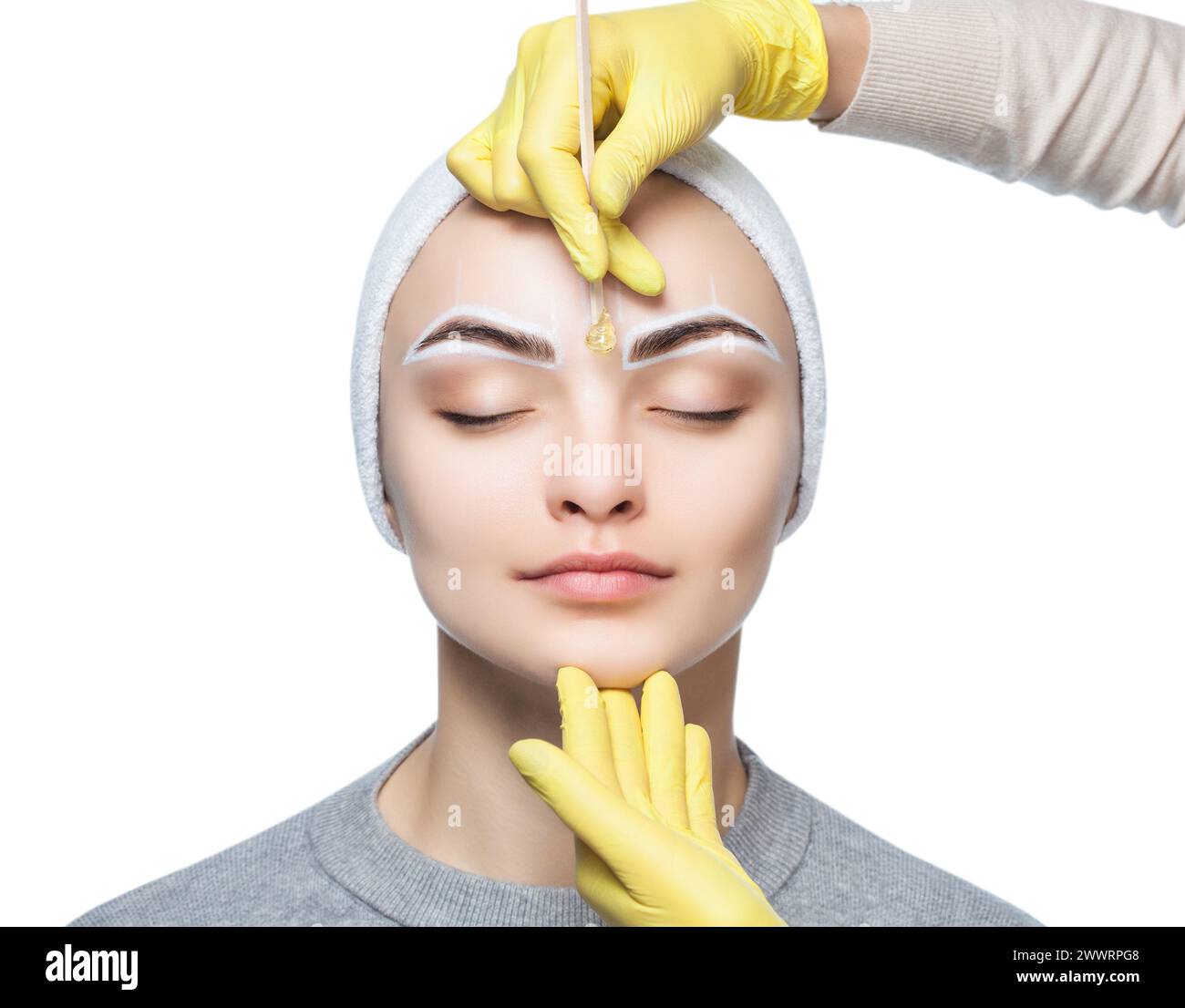 Die Make-up-Künstlerin zupft sich die Augenbrauen, bevor sie im Schönheitssalon dauerhaft schminkt. Stockfoto